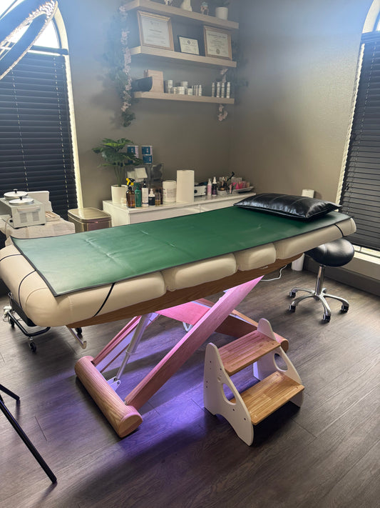 A professional esthetician at Beauty Bar by Mare in Spring, TX applies a soothing vajacial treatment after a Brazilian wax — brightening, calming serum on smooth, freshly waxed skin in a clean, private treatment room.